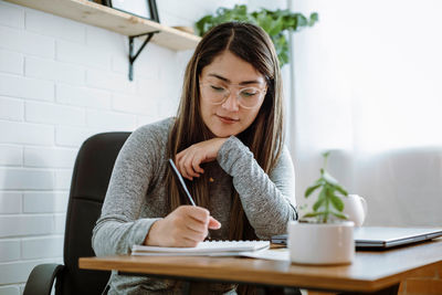 Mexican young woman works with natural pose in her home office