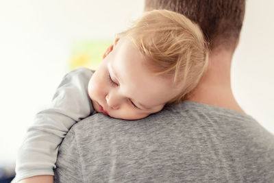 Baby sleeping on shoulder of father