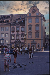 People walking on street against buildings in city