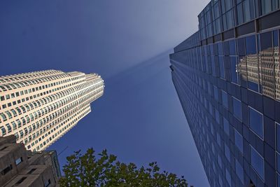 Low angle view of modern buildings against clear blue sky