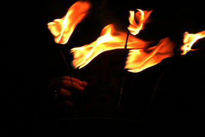 Close-up of man holding burning candle