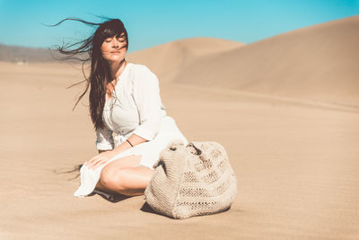 Happy young woman on sand at beach