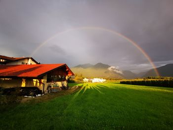 Scenic view of rainbow over houses against sky