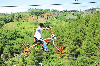 Man riding hanging bicycle