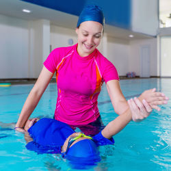 Mother teaching swimming to son in pool