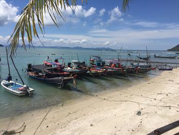 Boats moored at beach against sky