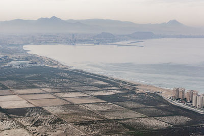 High angle view of city by sea against sky