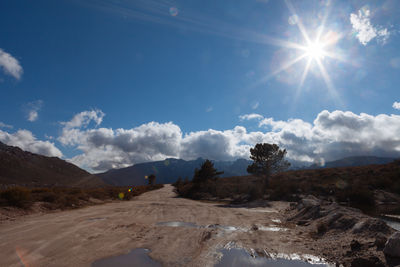 High angle view of country road against sunny sky