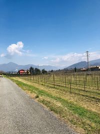 Road amidst field against sky