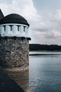 Building by sea against sky