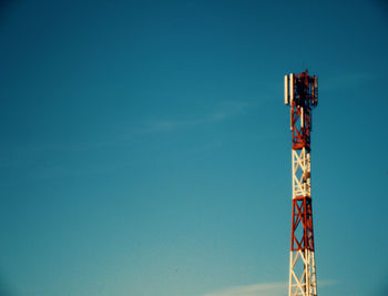 Low angle view of communications tower against blue sky