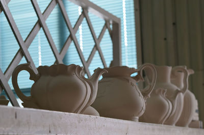 Close-up of clay containers on shelf at shop