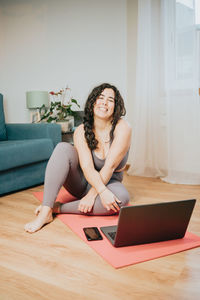 Overweight woman sitting by laptop at home