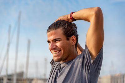 Portrait of young man looking away against sky