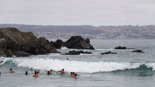 People on enjoying at sea against sky