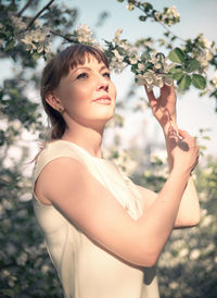Young woman portrait on the blooming apple trees background