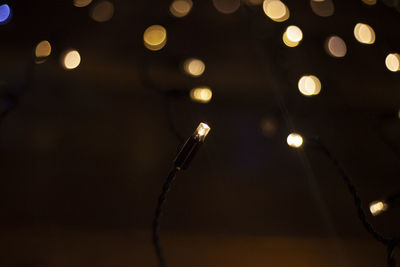 Close-up of illuminated electric lights at night