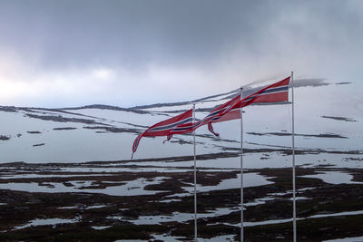 Low angle view of flags against sky
