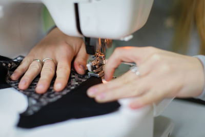 Cropped hands of woman sewing clothes on machine