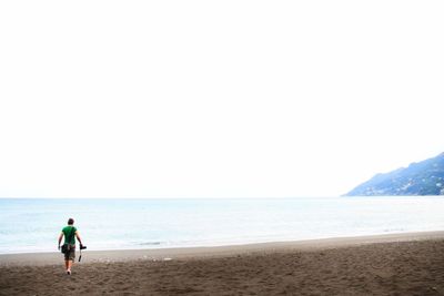 Full length of man on beach against clear sky