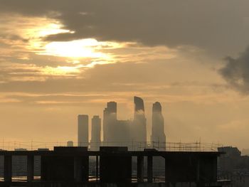 Silhouette buildings against sky during sunset