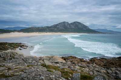 Scenic view of sea and mountains against sky