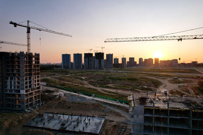 Buildings in city against sky during sunset