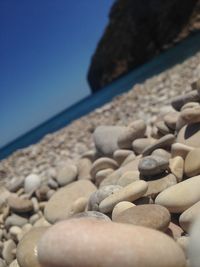 Close-up of pebbles on beach against sky
