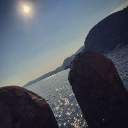 Rock formation in sea against sky