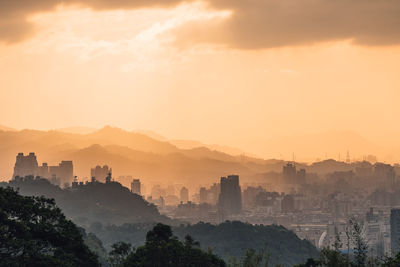 Buildings in city against sky during sunset