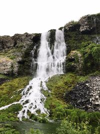 Scenic view of waterfall against sky