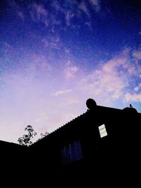 Low angle view of silhouette building against sky