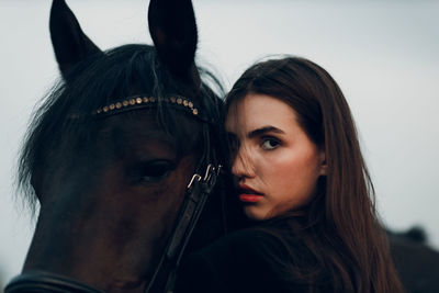 Close-up of young woman with horse