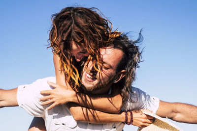 Smiling couple against sky