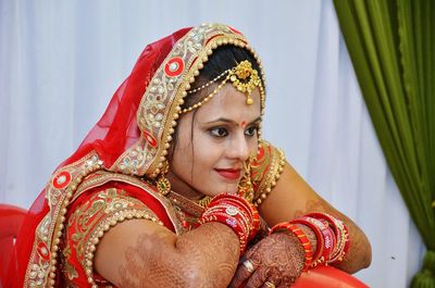 Close-up of bride against curtains