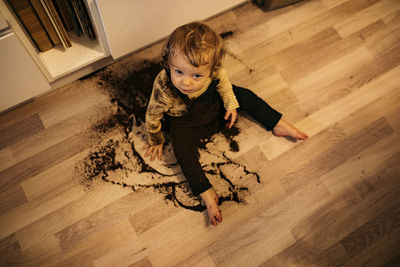 Boy sitting on floor in spilled coffee