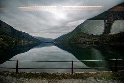 Scenic view of lake by mountain against sky