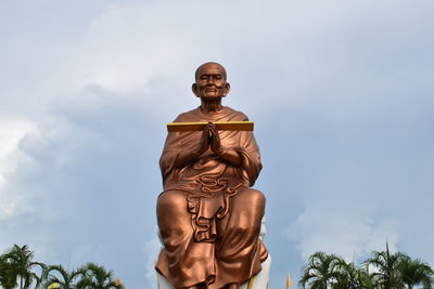 Low angle view of somdej toh statue at wat bot temple against sky