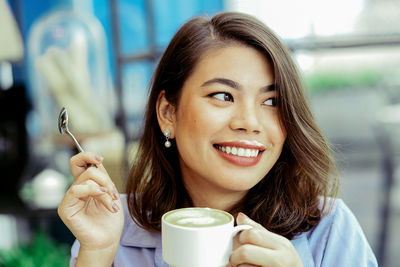 Portrait of young woman drinking coffee