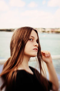 Beautiful young woman looking up at beach