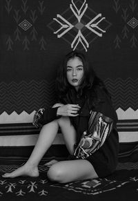 Portrait of young woman sitting on carpet at home