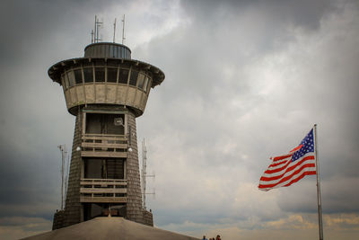 Low angle view of flag by building against sky