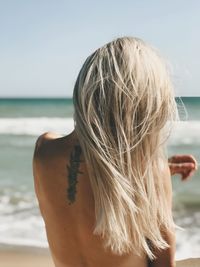 Rear view of woman standing at beach