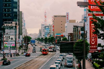 Traffic on city street by buildings against sky