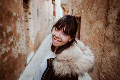 Portrait of smiling woman standing in snow