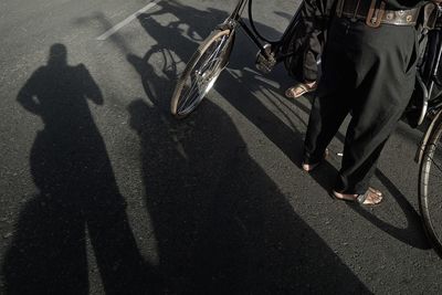 Low section of man standing on road