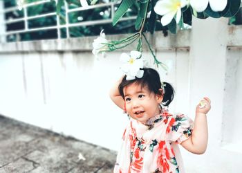 Cute baby girl standing by wall