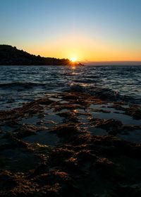 Scenic view of sea against clear sky during sunset