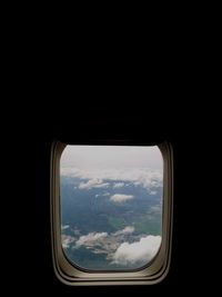 View of cloudy sky seen through airplane window