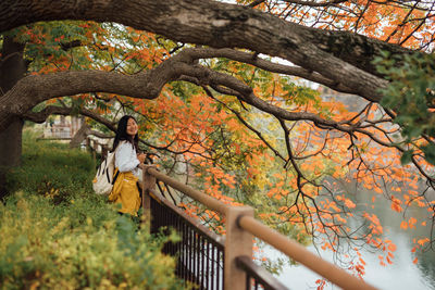 Side view of person standing by plants during autumn